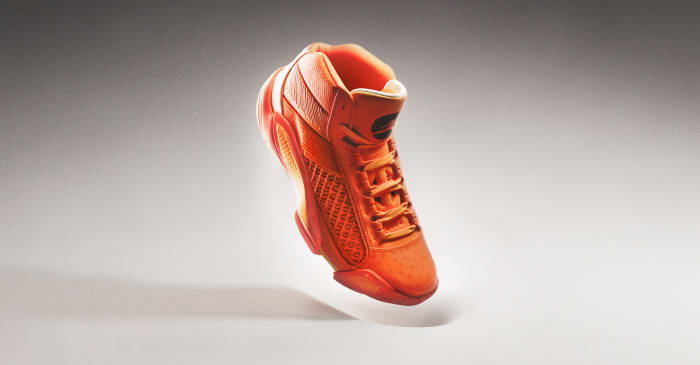 Side view of an orange and black Air Jordan basketball shoe.